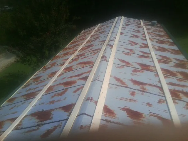 Rusted metal roof panels with new wood purlins before replacement — Storm Damage Roof Repair in Elysburg by Roofing Brothers
