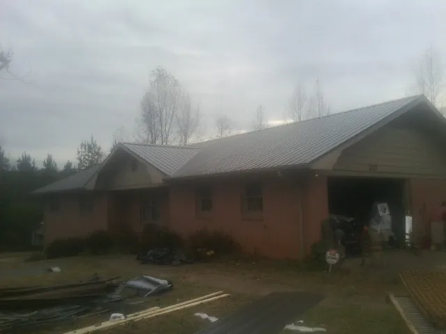 Gray metal roof on a stucco house with an attached garage in Elysburg