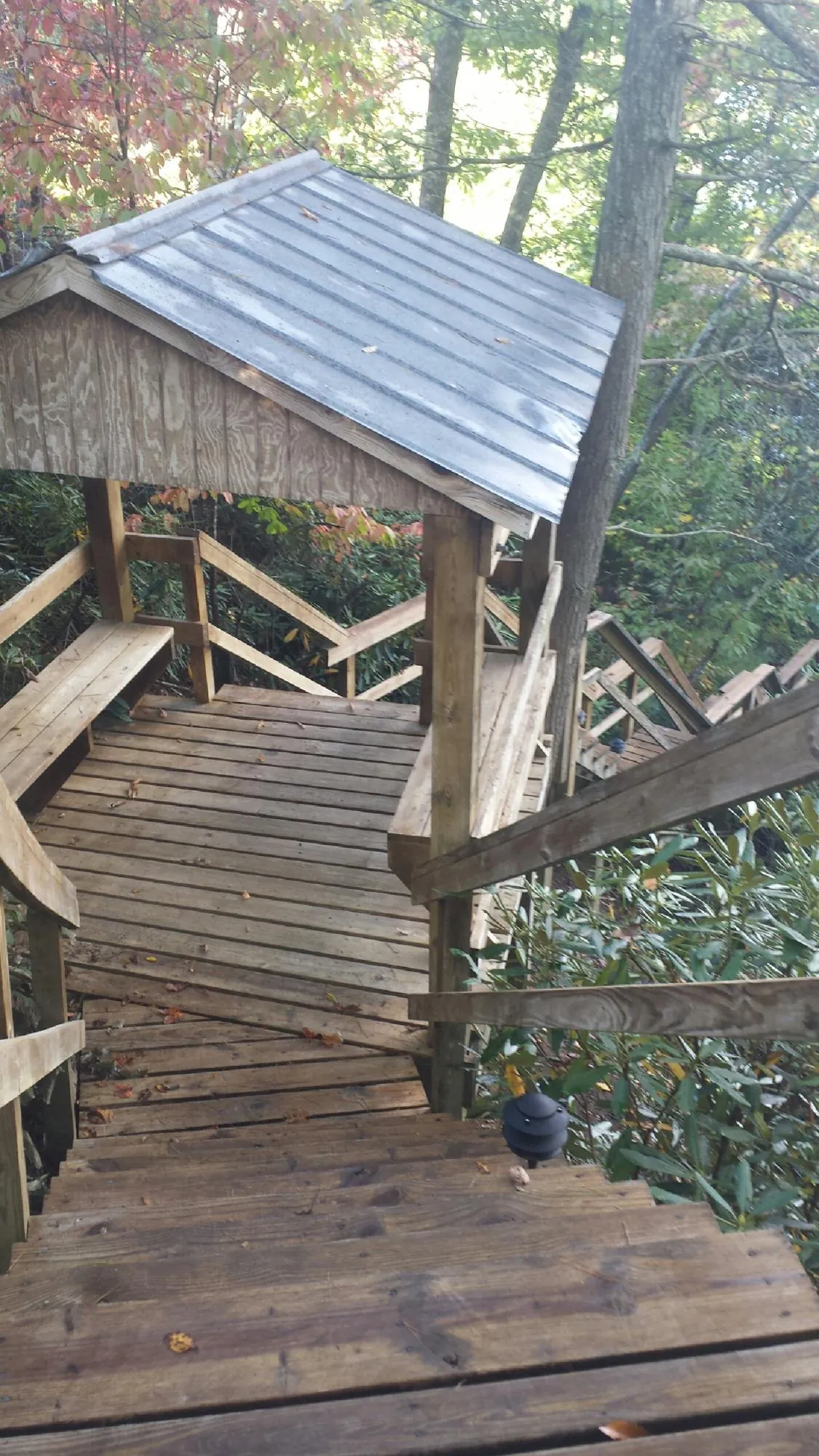 Metal roofed shelter over wooden steps on a wooded walkway — Skylight Repair & Installation work by our crew in Elysburg