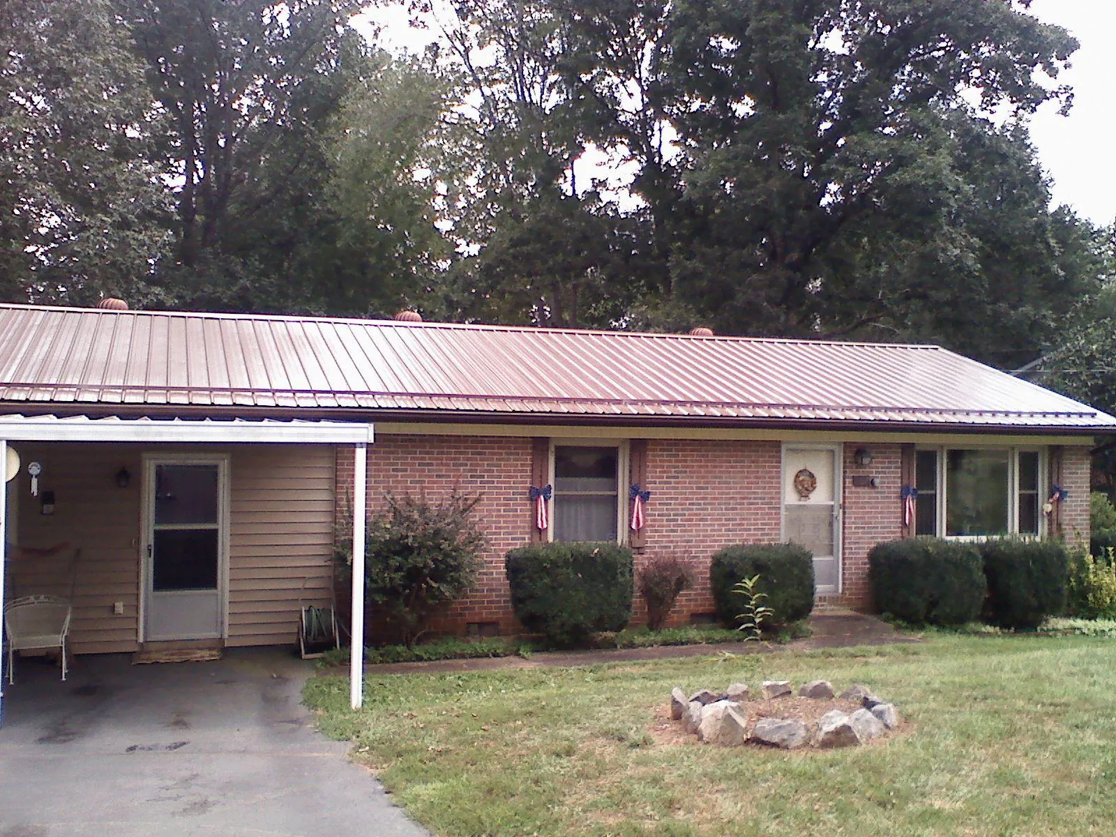 Bronze metal roof and carport on a brick ranch home — Roof Repair work by our crew in Elysburg